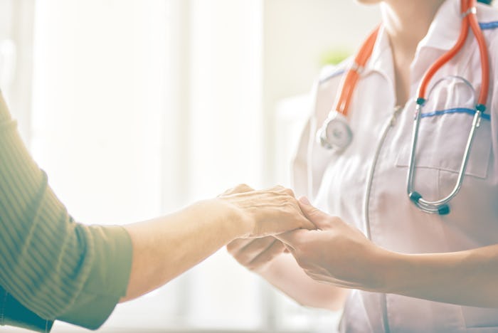 Nurse holding hands with patient