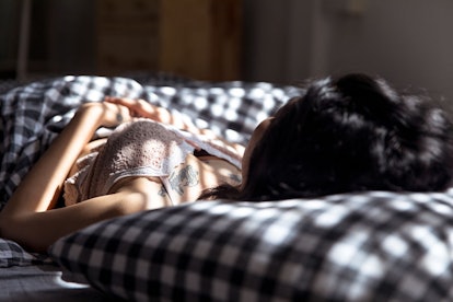 A woman with SAD lying in bed staring up at the ceiling 