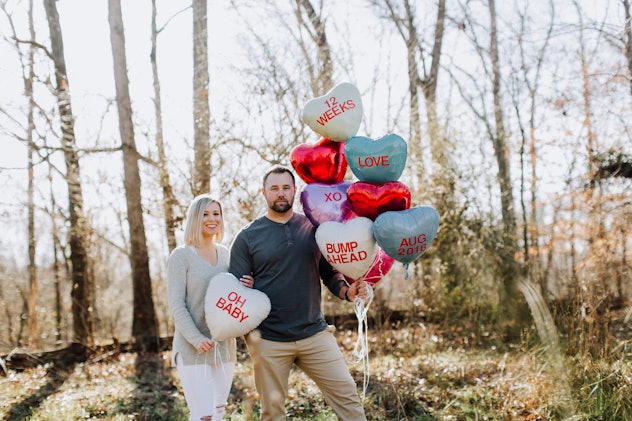 valentines day pregnancy announcement idea: couple holding candy heart balloons