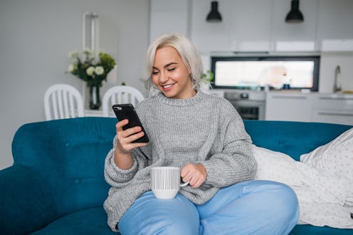A woman with bleached blonde hair swipes for dating app matches on Dating Sunday, the biggest dating...