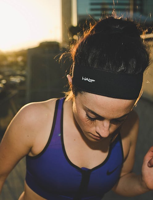 A woman wearing the Halo II Headband Sweatband Pullover and a workout top