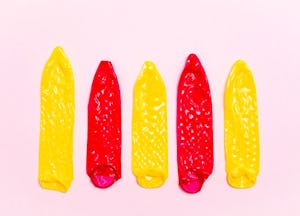 Three yellow and two red stretched condoms