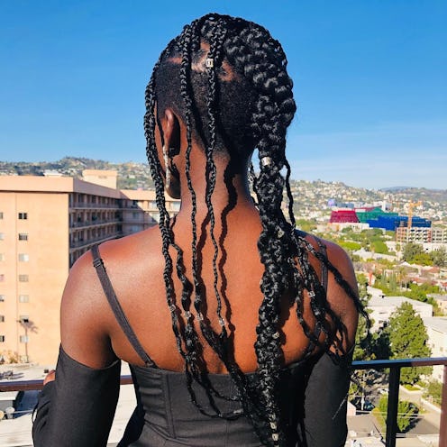 The back of a woman in a black top with a mini-braided natural hairstyle idea fo