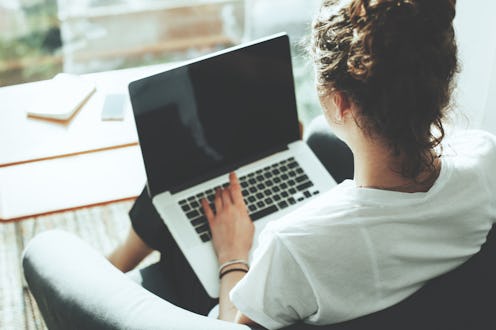 A woman working with her laptop on her lap