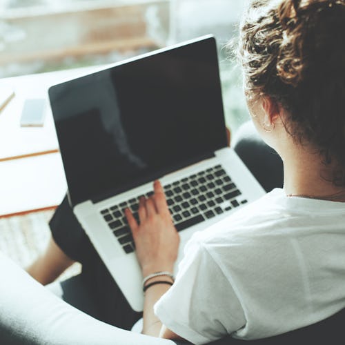 A woman working with her laptop on her lap