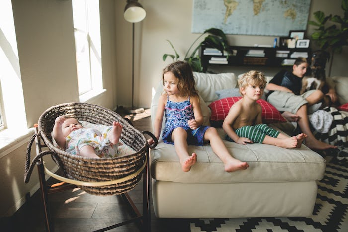 A big family with four kids of different ages sitting in a living room