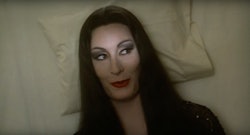 Morticia Addams on a pillow smiling 