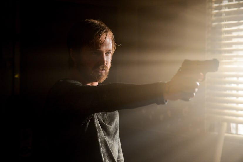 Aaron Paul as Jesse Pinkman holding a gun in the Breaking Bad finale