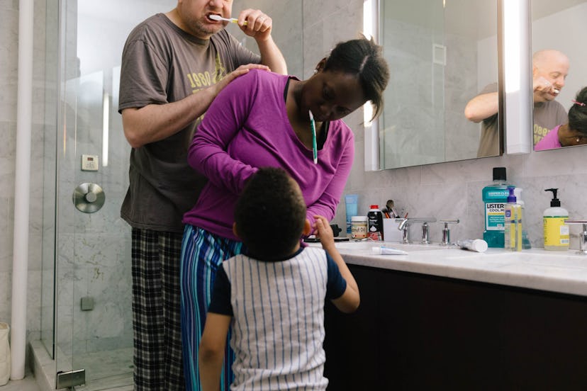 questions to ask the pediatric dentist the first visit, mom brushing her child's teeth in the bathro...