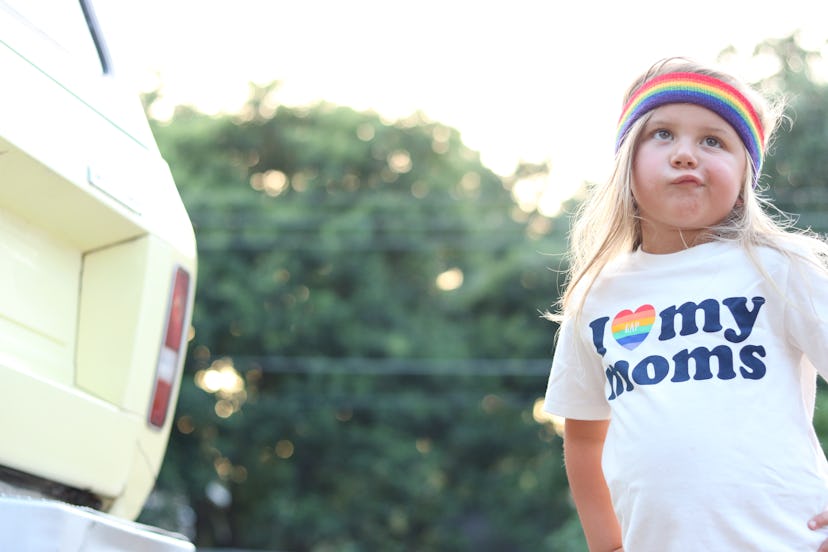 The author's 4-year-old daughter, wearing a rainbow headband and a t-shirt that says "I love my moms...