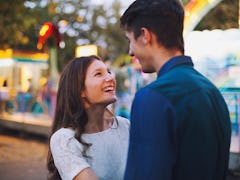 Woman smiling at her boyfriend at amusement park.