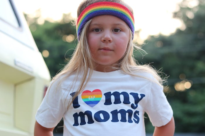 The author's 4-year-old daughter, wearing a rainbow headband and a t-shirt that says "I love my moms...