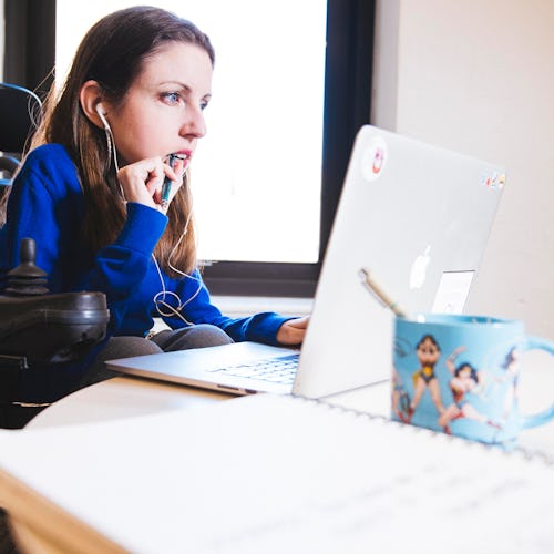 A woman looks over financial records at her desk. Saving For Retirement When You're In Your 20s does...