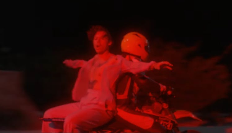 Harry Styles rides on the back of a motorcycle in his "Lights Up" music video.
