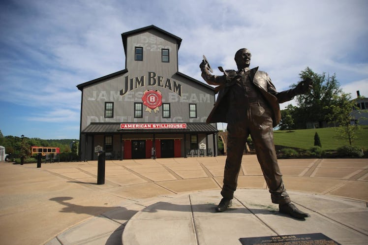 An exterior view of the Jim Beam American Stillhouse with a statue of Jim Beam in the front.