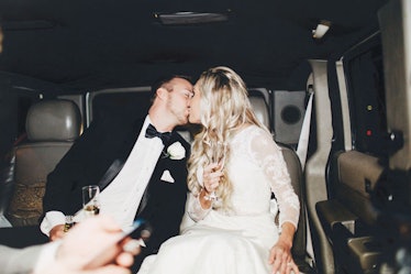 A bride and groom kissing on their wedding day in a limo with champagne is the perfect picture to po...