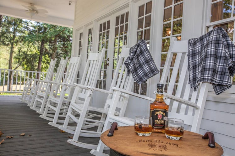 A row of white rocking chairs line the front porch of the historic home on the Jim Beam American Sti...
