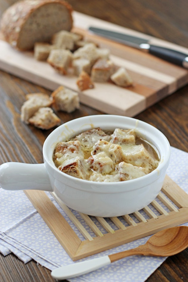 slow cooker french onion soup on a wooden slatted placemat