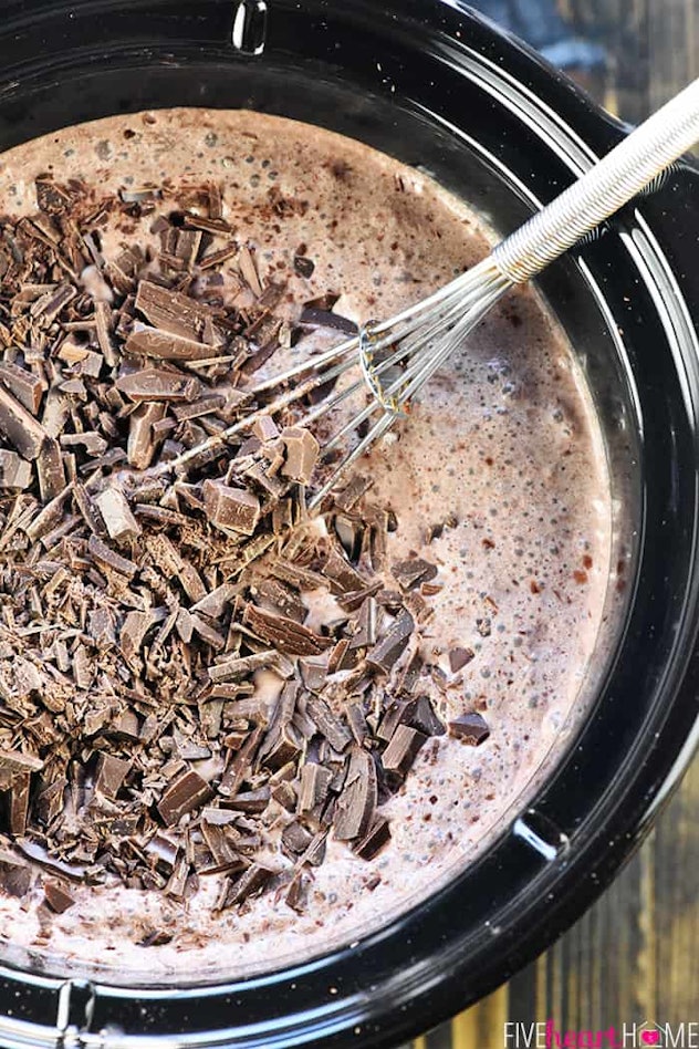 hot chocolate with chunks of chocolate on top cooking in slow cooker