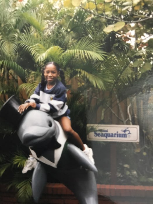 A picture of the author as a child, smiling in front of a Seaquarium sign.