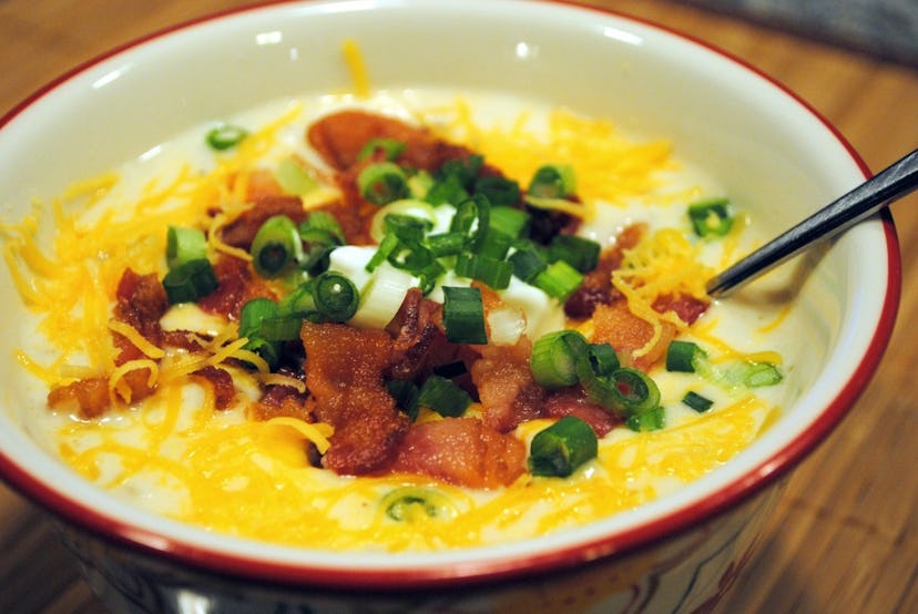 slow cooker potato soup with cheese bacon and scallions on top
