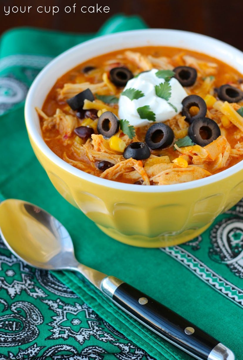 slow cooker chicken enchilada soup in yellow bowl on green placemat
