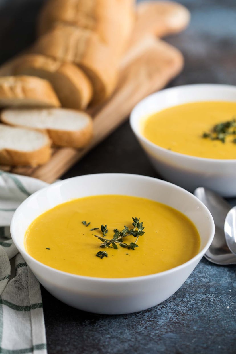 Yellow slow cooker butternut squash soup in white bowl