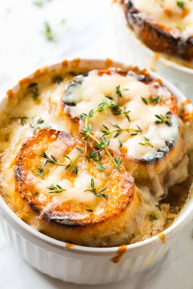 French onion soup in a ramekin with toasted bread and cheese