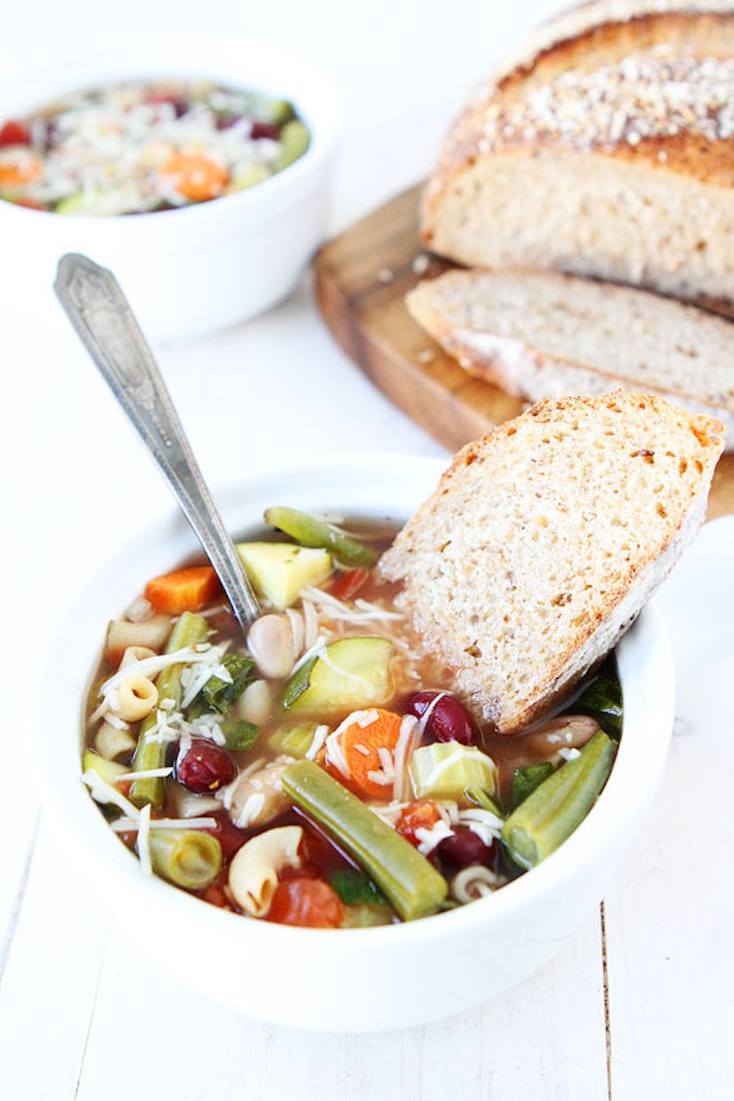 cup of slow cooker minestrone soup with a piece of bread on top