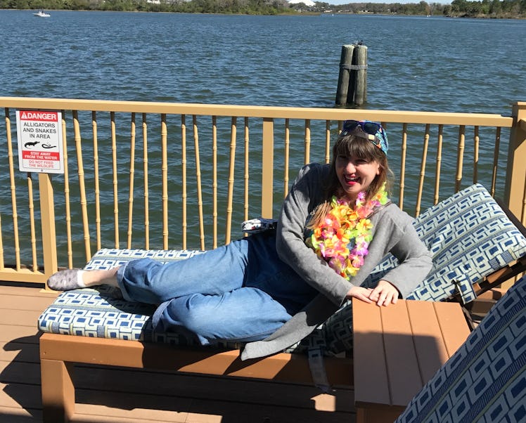 A brunette woman relaxing on the deck of a Disney bungalow on a sunny day.