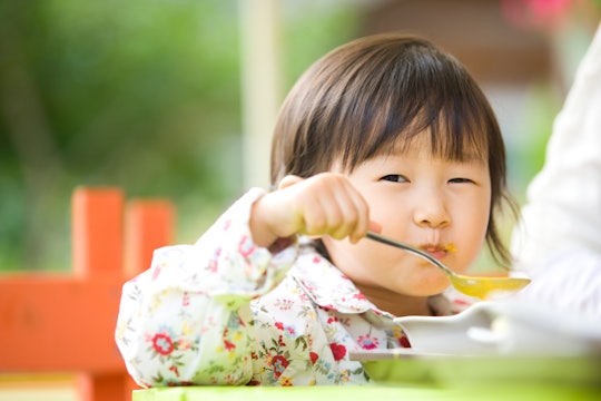 A little girl eating soup