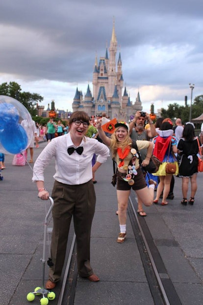 Two friends dressed like Carl and Russell from 'Up' pose for a picture in front of Cinderella's cast...
