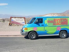 The Mystery Machine from 'Scooby-Doo' sits in the desert and is available to rent on Turo for Hallow...