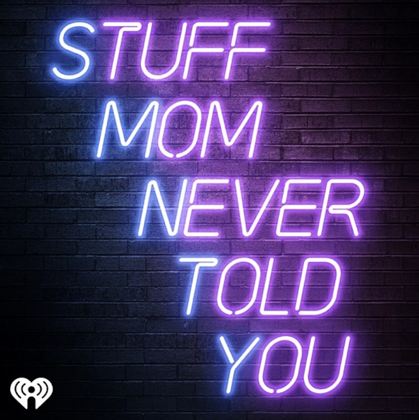 Stuff Mom Never Told You title in neon signage over a brick background