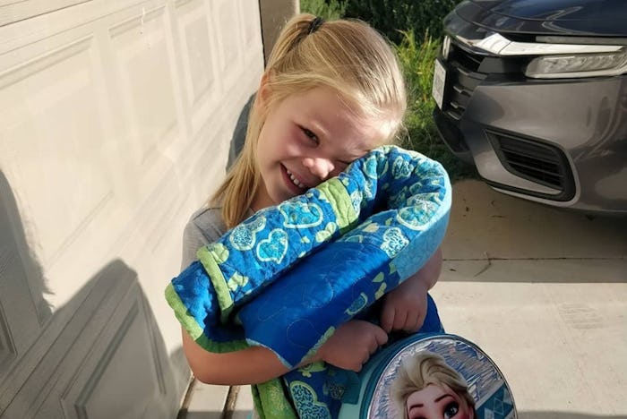 Girl cuddles her backpack