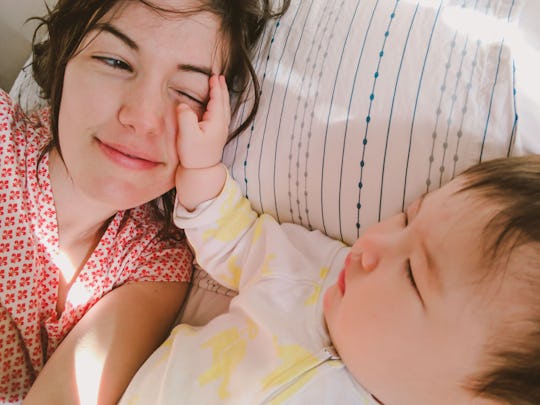 a mom lies in bed with her baby