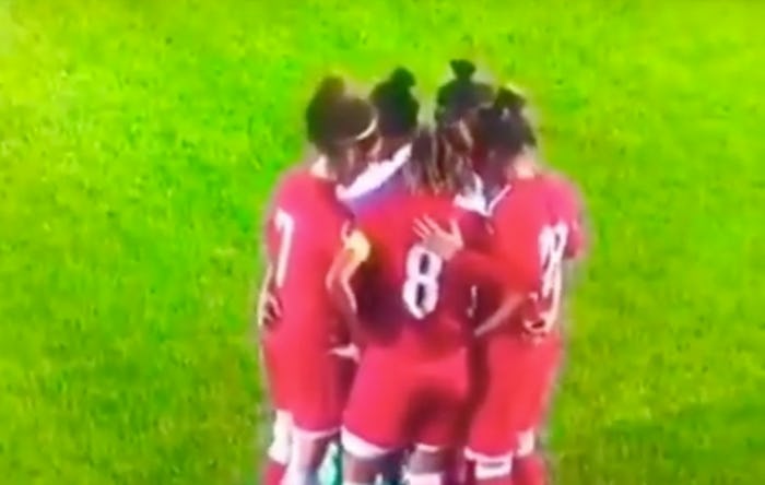 Soccer players surround opponent as she fixes her hijab which fell off during a game in Jordan.