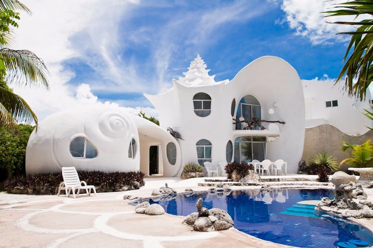 The exterior of the Seashell House on Airbnb features a private pool and unique white architecture.