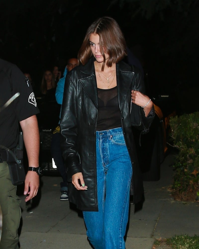 Kaia Gerber walking in dark and wearing a black leather coat