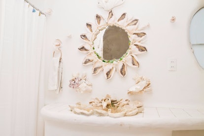 A bathroom in the Seashell House on Airbnb has a mirror and sink made of shells.