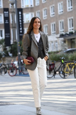 Street style photo of influencer Erika Boldrin wearing a tailored blazer over a leather vest with wh...