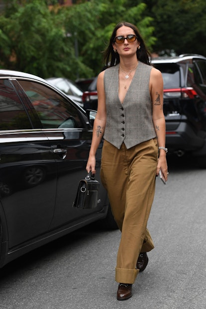 Street style photo of a woman wearing a tailored menswear vest at Fashion Week. 
