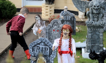 A young boy looks at the Halloween decorations displayed outside a house in Norris Green, Liverpool....