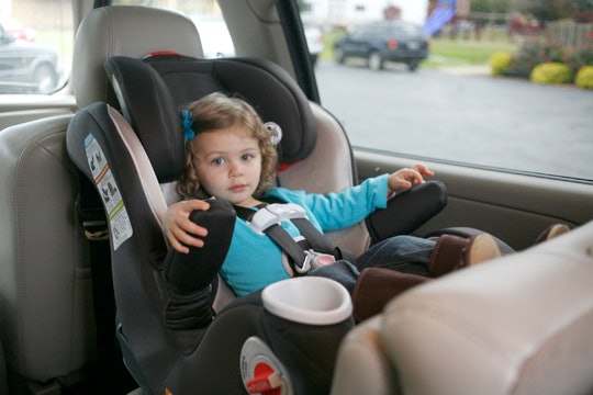 A toddler girl sitting in a car seat 