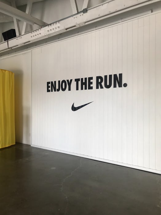 A white gym wall with Nike's sign and 'Enjoy the run.' written on it