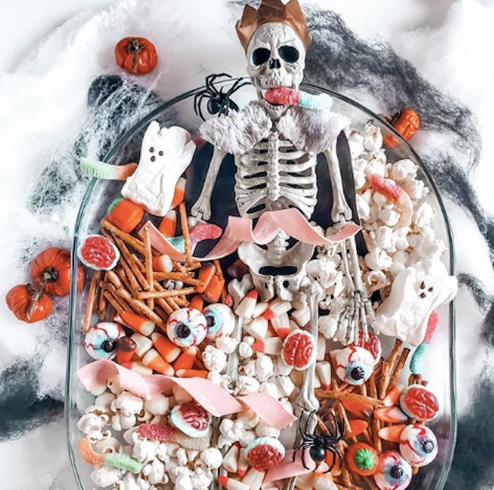 This candy Halloween charcuterie board features spooky treats like candy eyeballs and gummy worms wi...