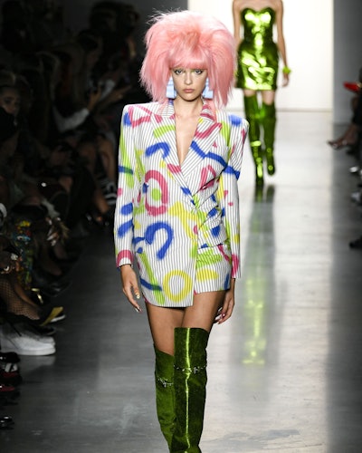 A model with pink hair, blue-pink-lime print blazer and lime metallic boots as on of the 7 Spring/Su...