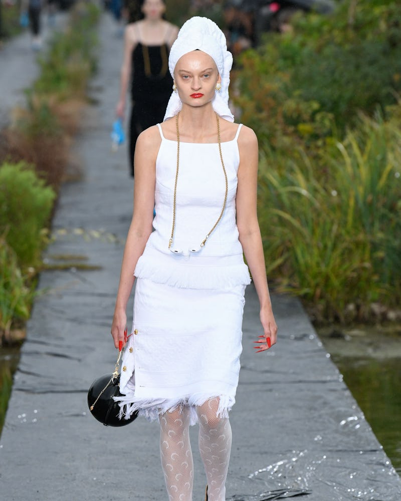 A model wearing a white dress and orange heels  as on of the 7 Spring/Summer runway shoe trends