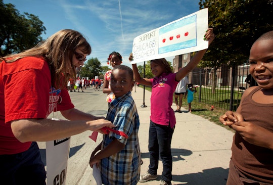 Karen Rieck, a teacher at Faraday Elementary School, greets her students as they show support for pu...