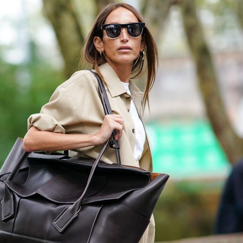 Street style photo of influencer carrying an oversized Bottega Veneta bag at London Fashion Week Spr...